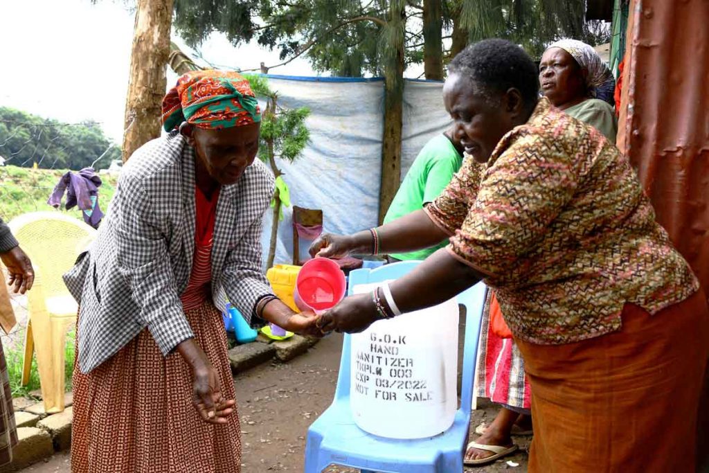 Agnes-Kariuki-L-demonstrates-how-a-government-of-Kenya-donated-hand-sanitizer-is-to-be-used.-1
